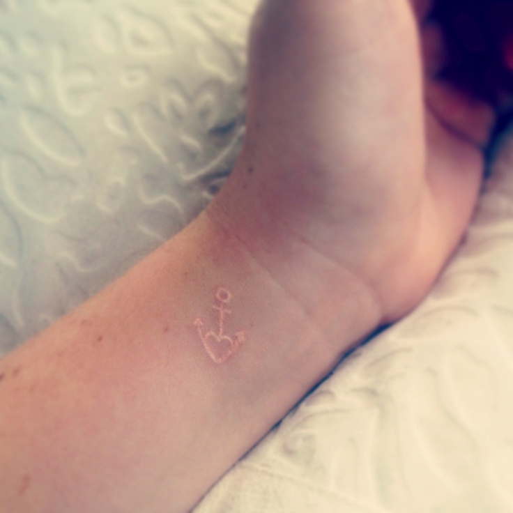 Minimalist anchor tattoo on China McClain's wrist.